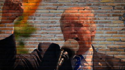 Donald Trump skriker i en mikrofon och höjer näven i luften.