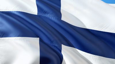 Finlands flagga blåser i vinden. Den är vit med ett blått kors.