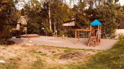 Bild på lekpark omringad av sko, hus och gräs.