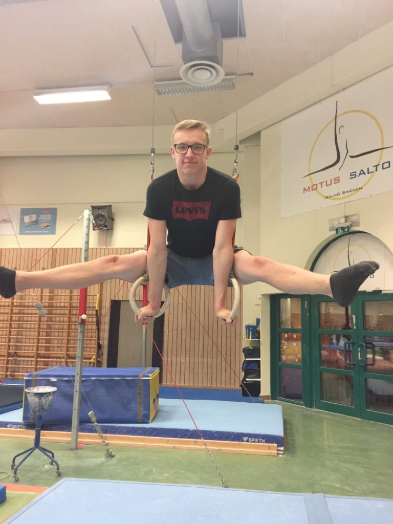 Victor gör en split medan han hänger i ringar.