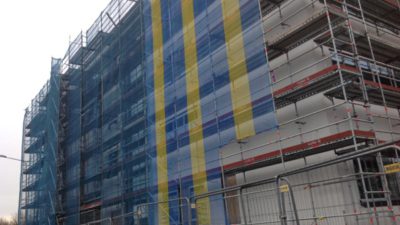 Närbild på en husfasad. De bygger en gymnasieskola.