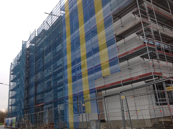 Närbild på en husfasad. De bygger en gymnasieskola.