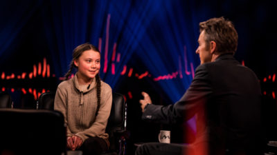 Greta Thunberg ler där hon sitter i en fåtölj i en TV-studio och blir intervjuad av den norska programledaren Fredrik Skavlan.