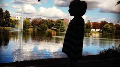 Flicka i siluett i park