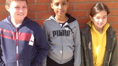 Tre elever mot en tegelvägg