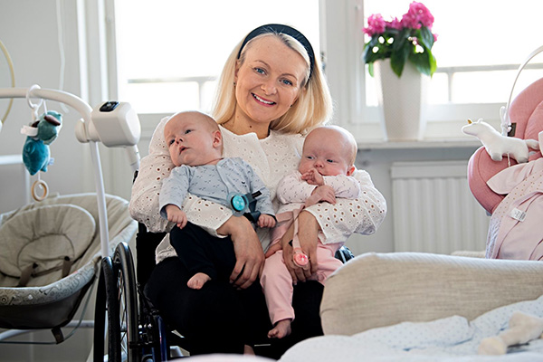 Foto på Matilda när hon håller sina två bebisar.