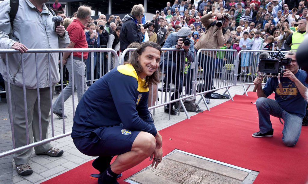 Zlatan står på huk och blir fotograferad