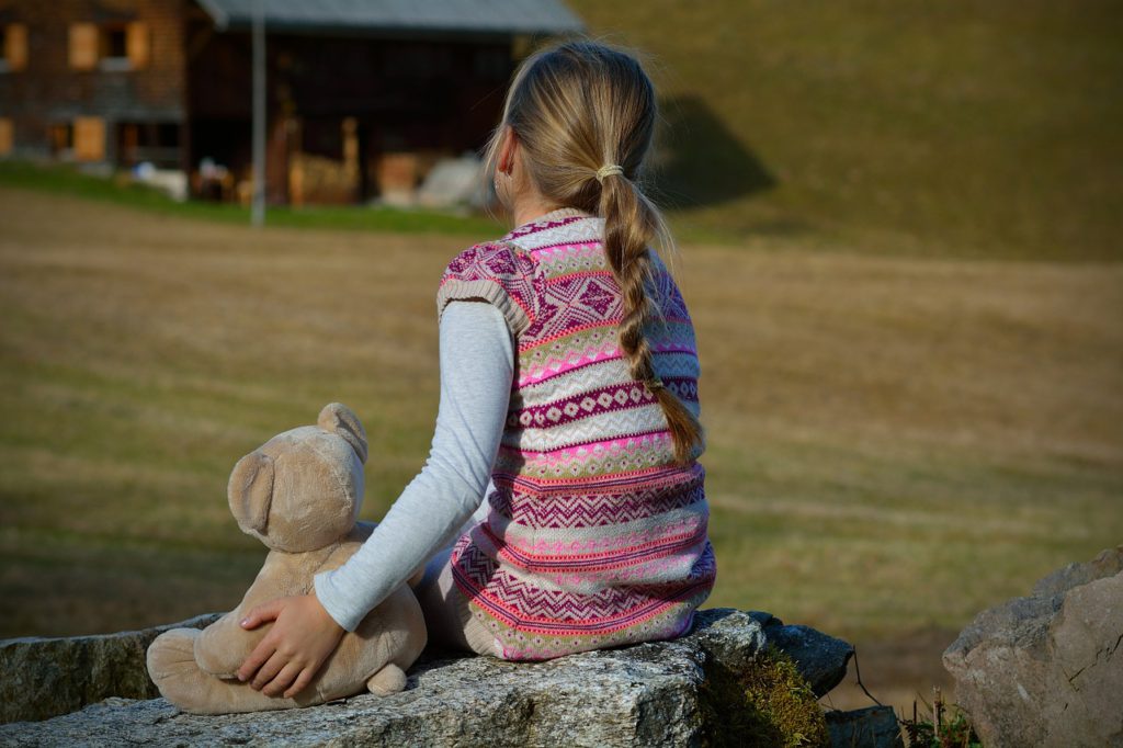 Ett barn som sitter med en nalle