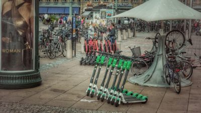 Gröna och röda elsparkcyklar som står på rad