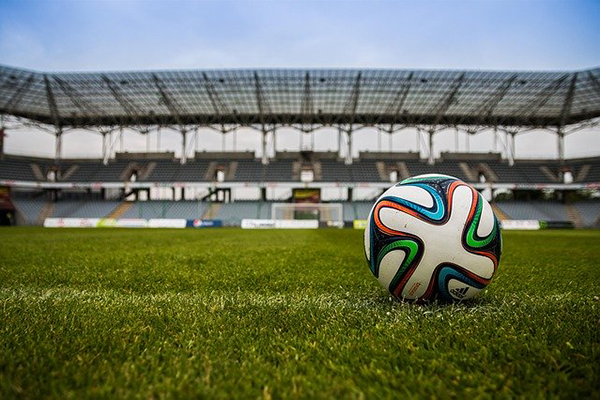 Foto på en fotboll på en stor fotbollsplan.