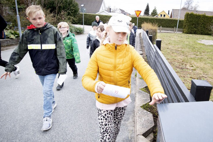 Alva Ryman och Nils Pärmelöv lägger lappar i brevlådor.