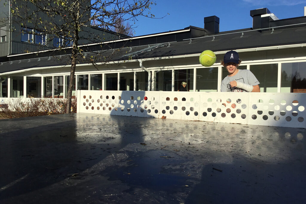 En tennisboll som flyger över nätet på ett pingisbord.